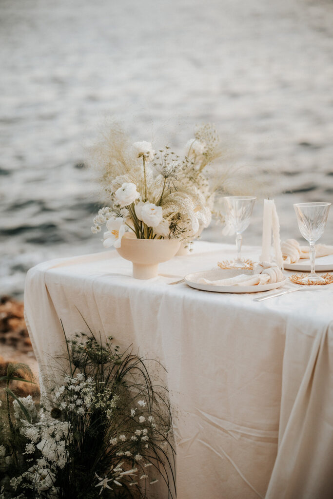 Centro de mesa con flores naturales en mesa de boda junto al mar